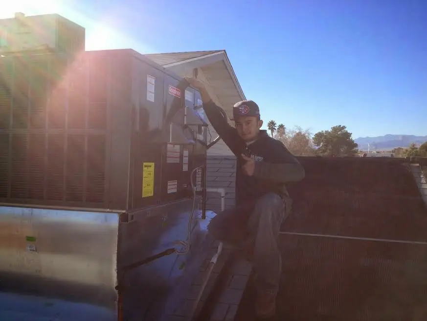 HVAC technician performing Boiler Repair on a rooftop unit in Monona